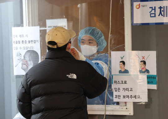 지난달 25일 오전 서울역 코로나19 임시선별검사소에서 의료진이 코에 면봉을 넣어 비인두도말 검체를 채취하는 PCR 검사를 하고 있다. <연합뉴스>